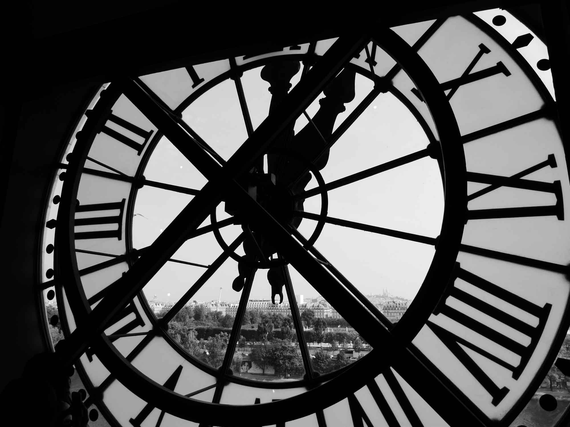 Black and white photo from inside clock tower through clock face